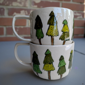 Zestaw dwóch ręcznie malowanych kubków z motywem zimowych choinek.